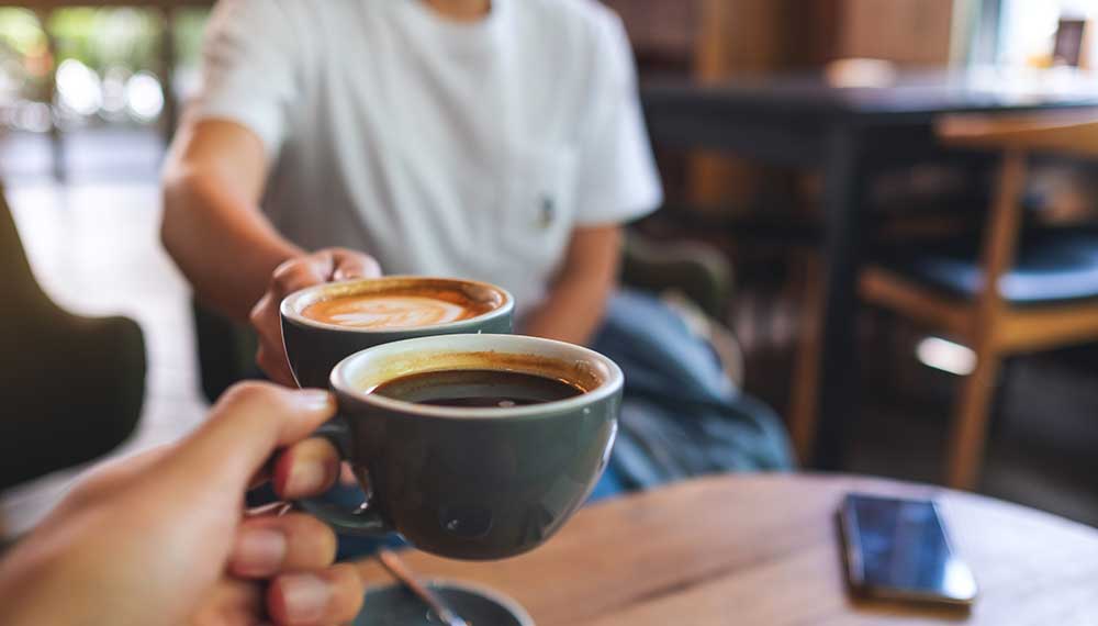 two coffee cups cheersing