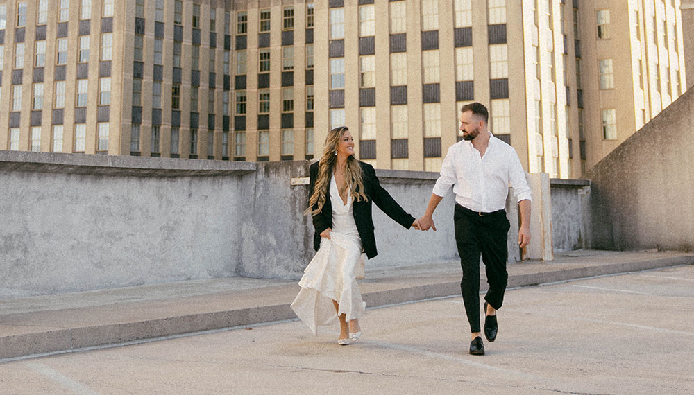 Couple’s engagement photo in front of tall building